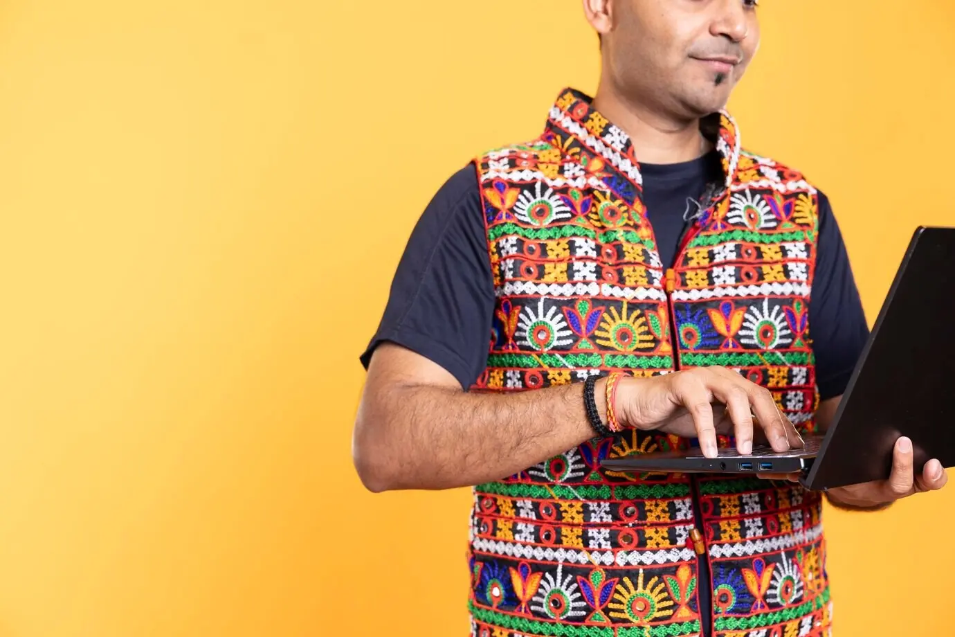 A man using a laptop to carry out business-related tasks for a company.